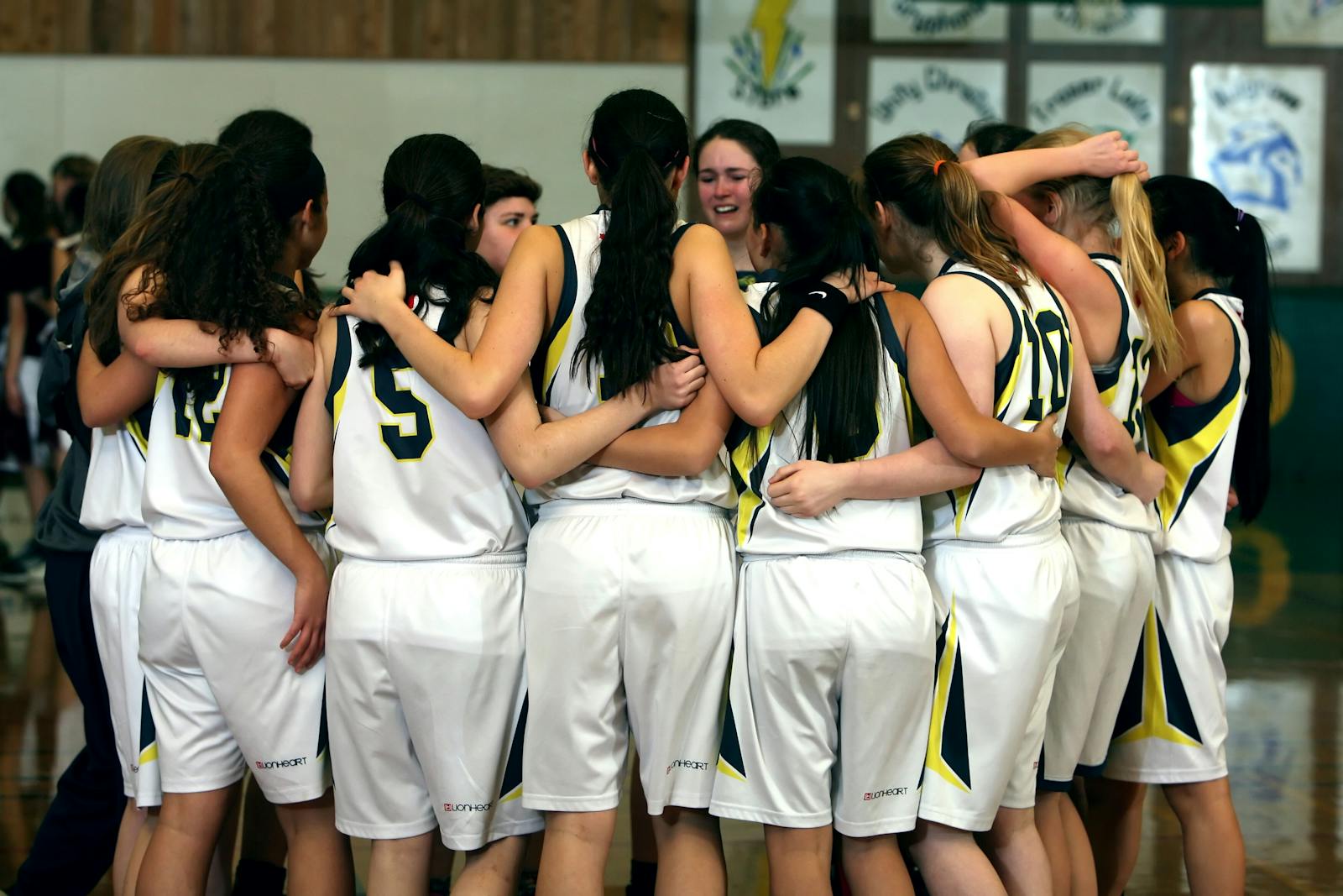 Equipe de basket Joueuses de basket formant un cercle pour s'encourager au milieu du terrain